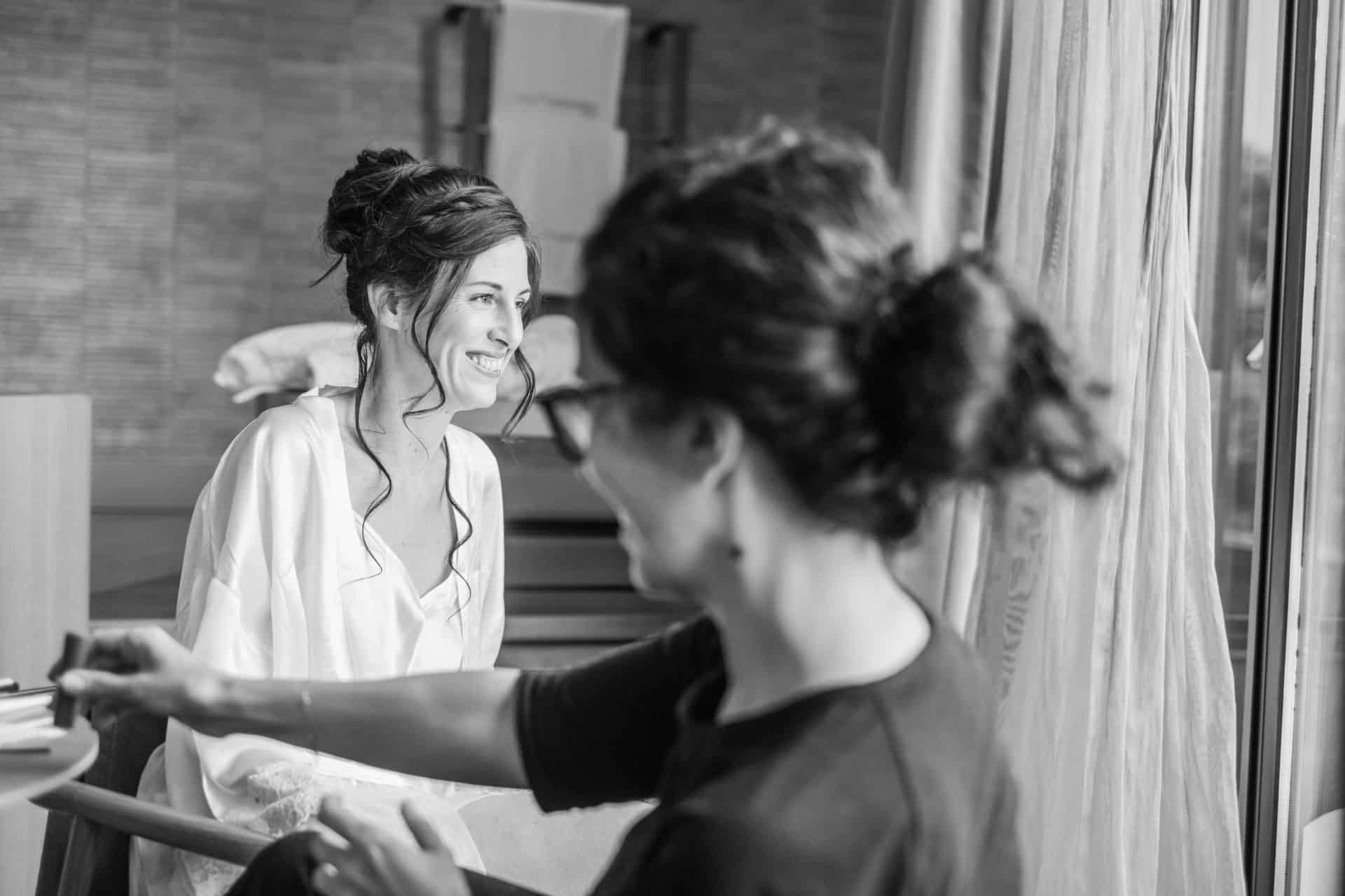 Diana sonriendo durante los preparativos mientras recibe su maquillaje de novia natural