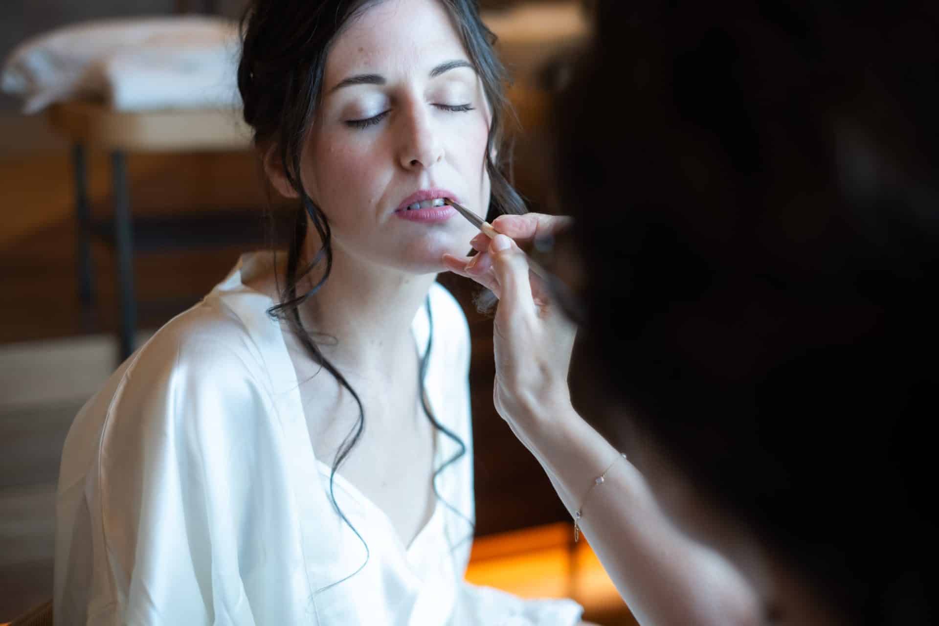 Aplicación de maquillaje de novia natural durante los preparativos de Diana antes de la ceremonia