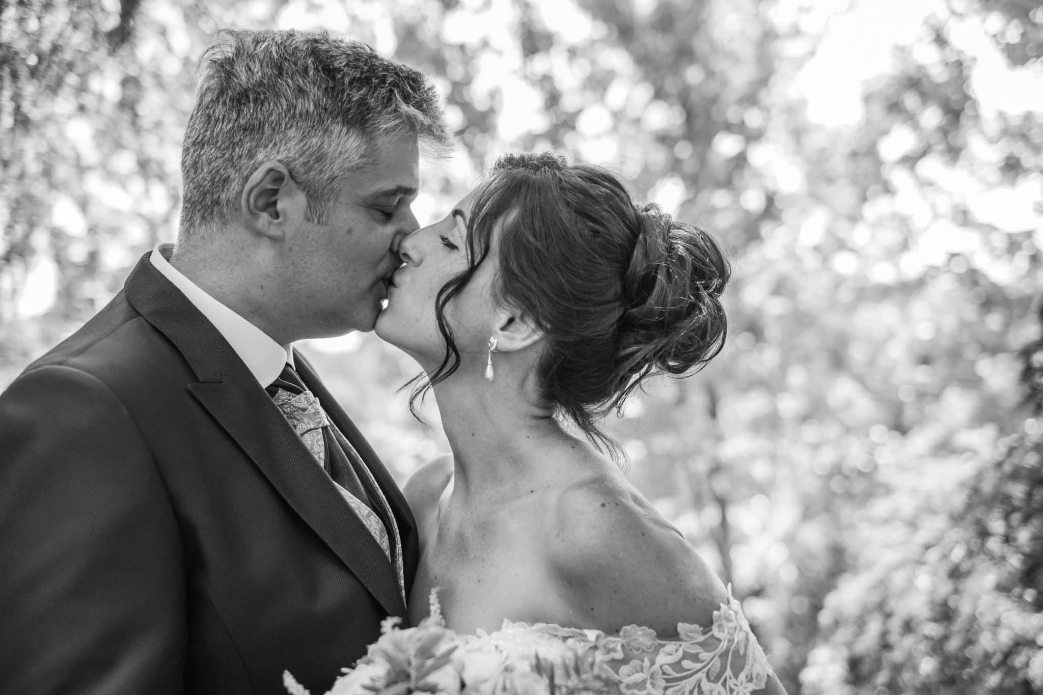 Diana y su marido besándose después de la ceremonia con maquillaje de novia natural y recogido elegante