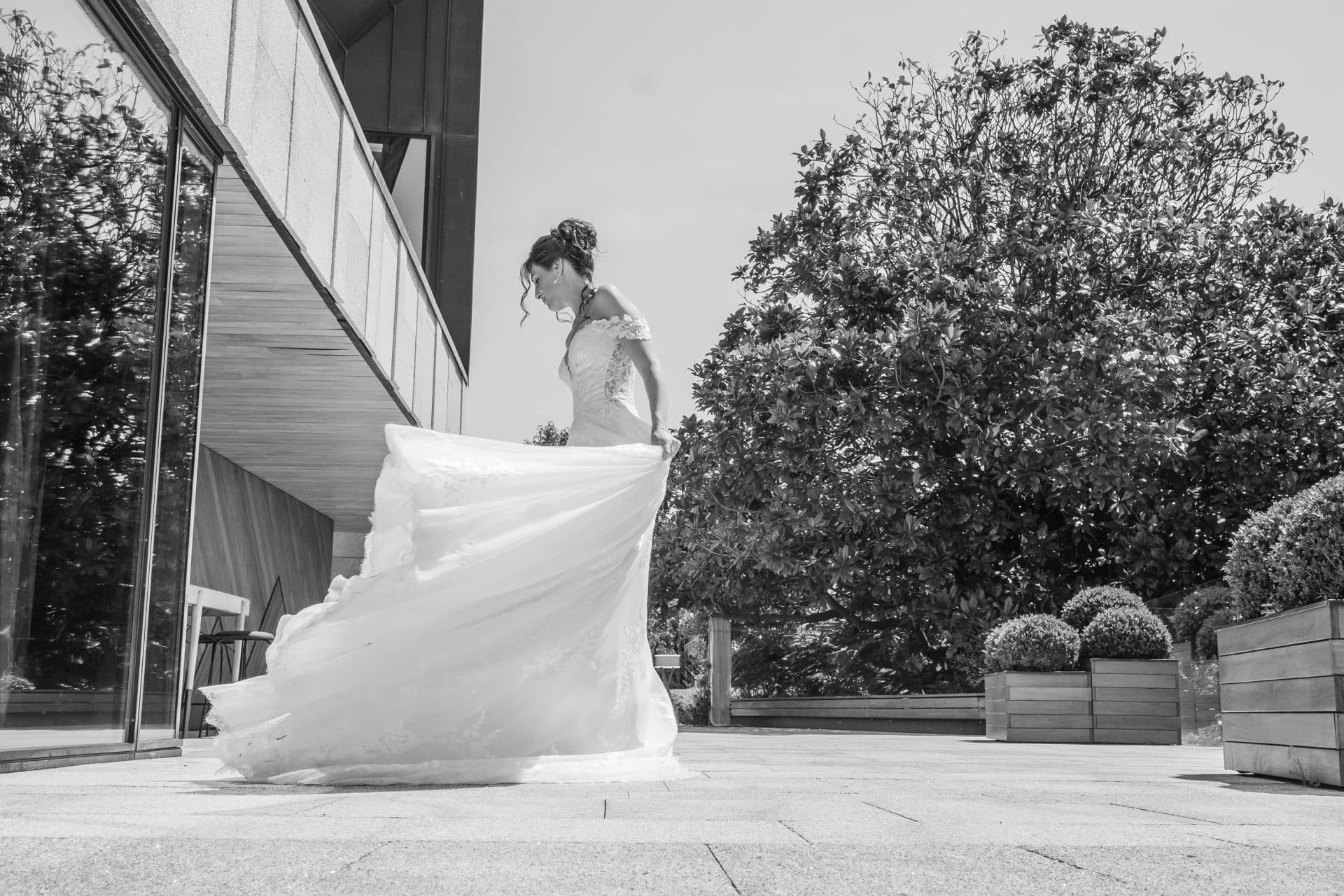 Diana jugando con su vestido de novia antes de la ceremonia con peinado recogido y maquillaje natural.