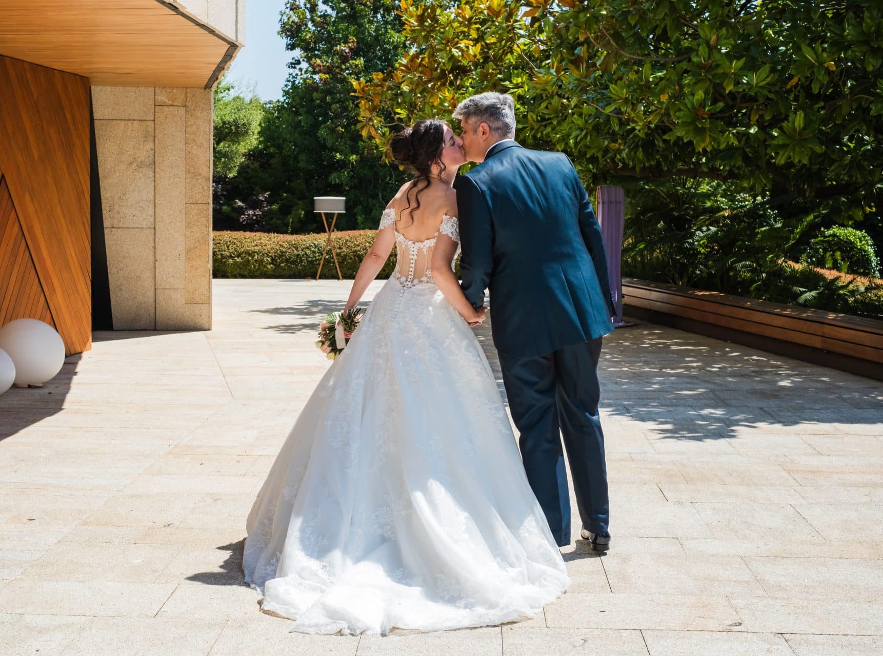 un beso de los recién casados camino de la recepción en Finca Montesqueiro